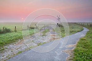 Bicycle road to windmill in fog