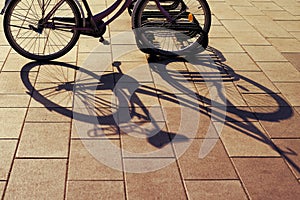 Bicycle shadow parked at sunset in the evening