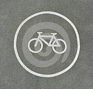 Bicycle sign on asphalt texture marking cyclist lane on a road.