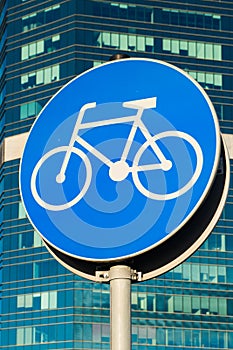 Bicycle sign on skycrappers background. Bycicle road