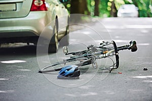 Bicycle and silver colored car accident on the road at forest at daytime