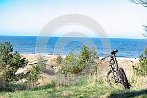 Bicycle standing on dunes by the sea shore with view to the Baltic sea