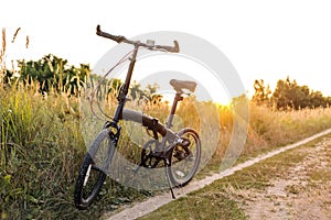 Bicycle stands on a country road at sunset, a break in a bike ride