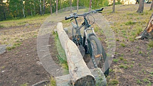 The Bicycle Stands Near the Wooden Log in the Forest Edge. Smooth Camera Movement. Cycling and Cycling Concept