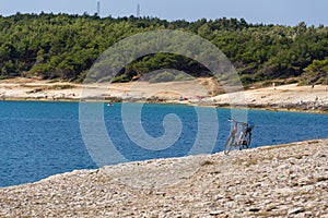 Bicycle on stony beach, Kamenjak peninsula, Adriatic Sea, Premantura, Croatia photo