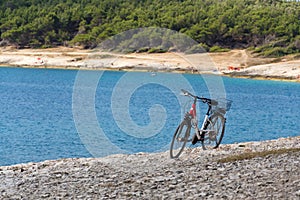 Bicycle on stony beach, Kamenjak peninsula, Adriatic Sea, Premantura, Croatia photo