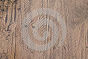 Bicycle tire tracks and footprints in sand