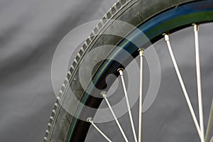 Bicycle tire and wheel close-up on a black background. Abstract background of a wheel in a bicycle workshop. Dirty old worn-out