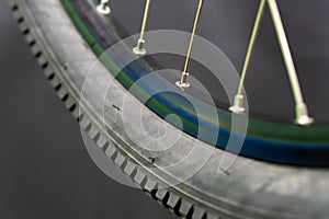 Bicycle tire and wheel close-up on a black background. Abstract background of a wheel in a bicycle workshop. Dirty old worn-out