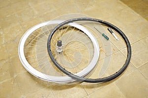 Bicycle wheel and airless tire disassembled on the floor of a bike repair shop