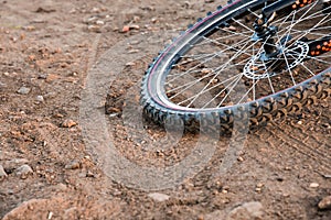 A bicycle wheel on a dirt road. Sports bicycle close-up.