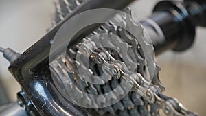 Bicycle wheel gear and chain in motion. Bike drivetrain and cassette, close up. Bike repair. Cycling workshop. Rotating bicycle ch