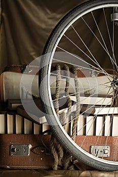 Bicycle wheel and old torn suit-case full of books
