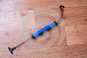 Bicycle wheel pump on wooden floor closeup