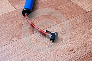 Bicycle wheel pump on wooden floor closeup