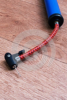 Bicycle wheel pump on wooden floor closeup