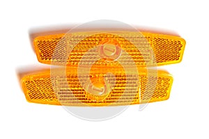 Bicycle wheel reflectors isolated on white. Two orange plastic reflectors for a bike spoke for safety at night