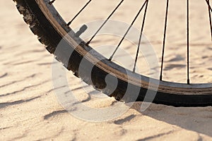 Bicycle wheel on the sand in the desert close up