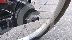 Bicycle Wheel Steel spokes and central wheel mount to the bike frame close-up. Nut on the bolt. Metal parts are qualitatively