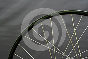 A bicycle wheel without a tire on a black background in the workshop. Bicycle repair. Rim and spokes of a mountain bike wheel