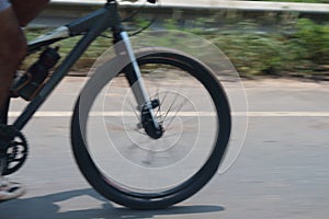 Bicycle wheels rotate at high speeds on the road and blur.