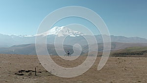 Bicycle woman riding bike on snowy mountain peak background. Tourist girl traveling on sport enduro full suspension e