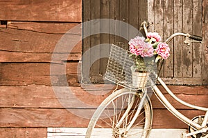 Bicycles old vintage flowers in a basket. Parked on the sidewall of the wooden house ideal for design work Classic hoodie style photo