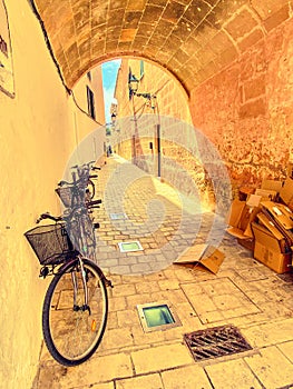 bicycles propped against wall in sunny and vibrant street in ciutadella menorca spanish balearic islands
