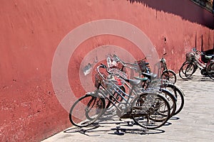 Bicycles beside red wall