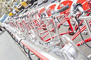 Bicycles stand in a row on a parking for rent.