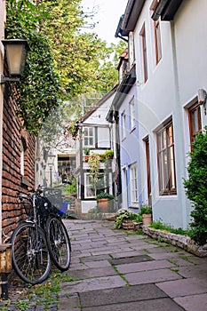 Bicycles and trees in cozy backyard. Summer patio with bikes. Bicycles in front of old house. Traditional exterior in Europe.