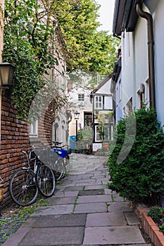 Bicycles and trees in cozy backyard. Summer patio with bikes. Bicycles in front of old house. Traditional exterior in Europe.