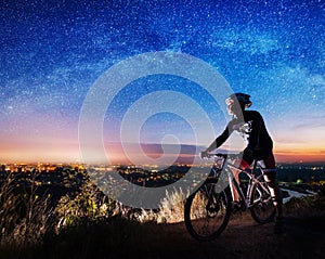 Bicyclist with mountain bike on top of the hill