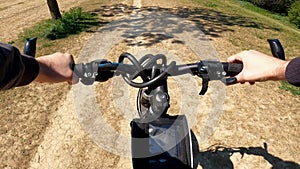 Bicyclist riding a bicycle in the city park, POV point of view