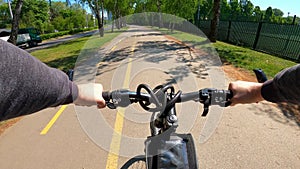 Bicyclist riding a bicycle in the city park, POV point of view