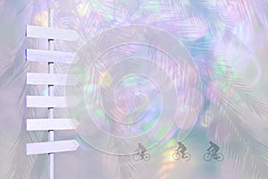 Bicyclists and wood arrow signpost on violet and color blurry lights soft pink