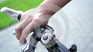 Bicyle braking, female hand using bicycle bell and brake for sudden stop