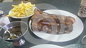 Bife de tira, Montevideu Market, Uruguay. Typical Barbecue with french fries and chimichurri sauce photo