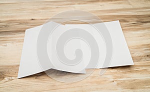 Bifold white template paper on wood texture.