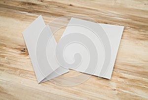 Bifold white template paper on wood texture.