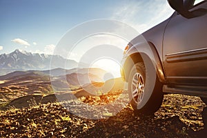 Big 4x4 car against sunset and mountains