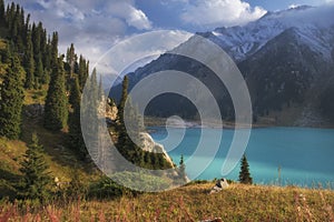 Big Almaty Lake in Tien Shan mountains of Kazakhstan. a Panorama of Beautiful mountain landscape on a fall evening with white