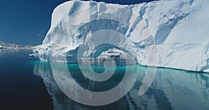 Big Antarctic iceberg arch float turquoise water