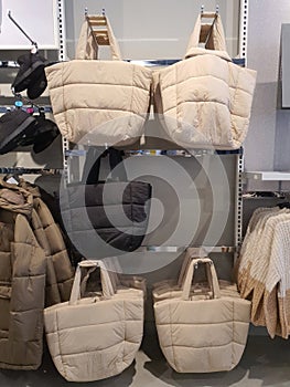 Big bags hang on rack in clothing store