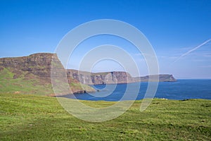 Big beautiful cliffs and green field.