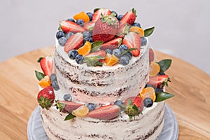 Big beautiful and delicious cake with strawberries, blueberries and tangerines.