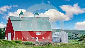 Big beautiful red barn with puffy clouds