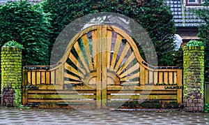 Big and beautiful wooden garden gate with a sun pattern, modern outdoor architecture