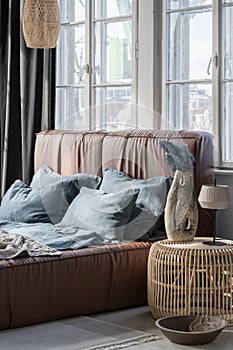 Big bed with leather headboard in bright bedroom