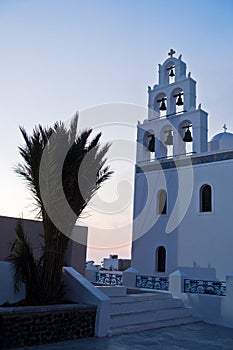 Big bell tower of Panagia church in Oia village after sunset at Santorini island